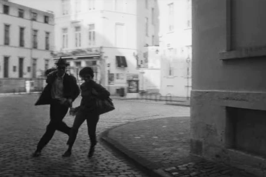 man and woman running through the street