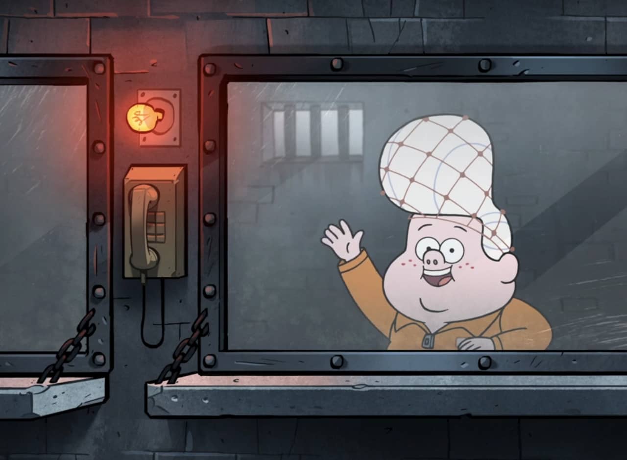 Li’l Gideon waves from behind prison visitation glass, wearing an orange jumpsuit and hairnet