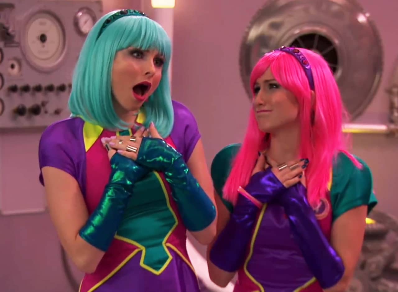 Linda and Heather, two teens, one with blue hair and the other with pink
