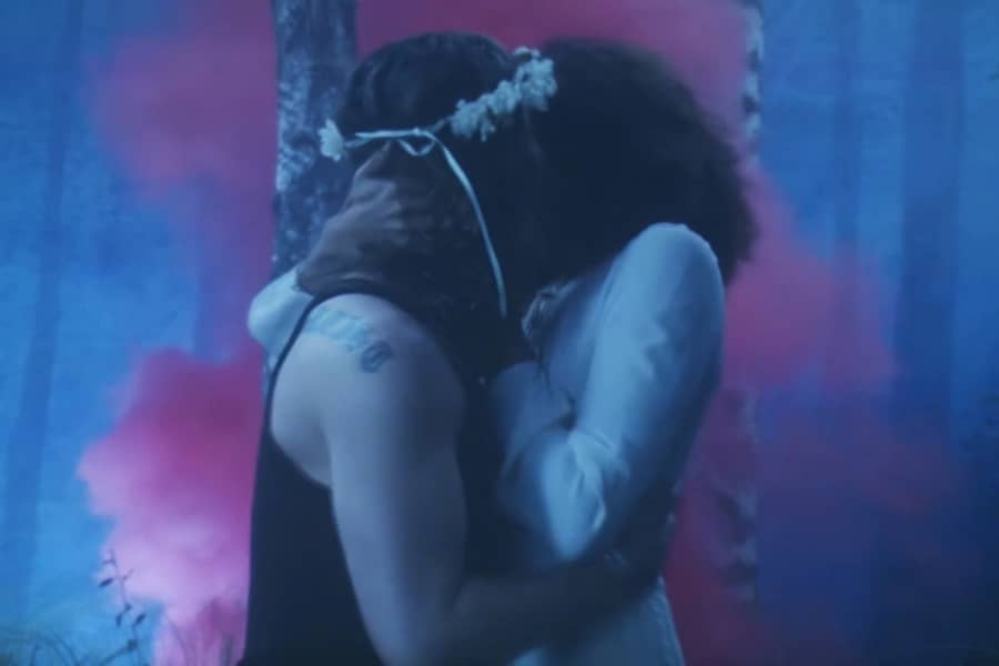 the couple kissing as pink mist spreads behind them