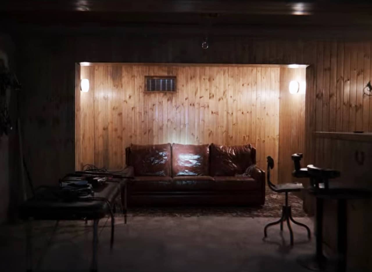 a dark, wood paneled room and an illuminated leather couch
