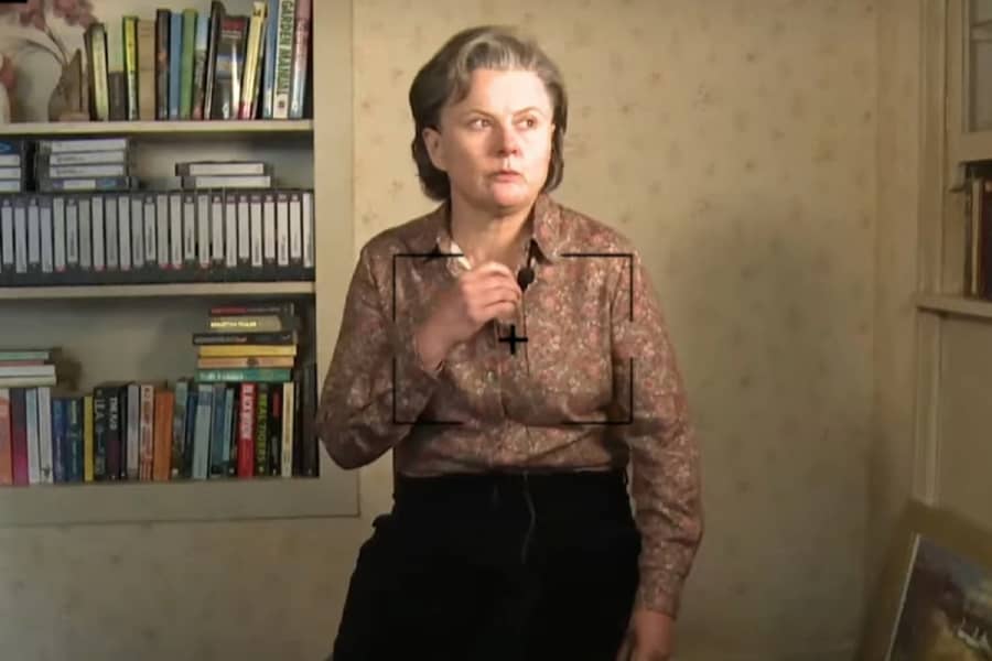 Janet McCardle setting up for an interview with a shelf of video tapes behind her