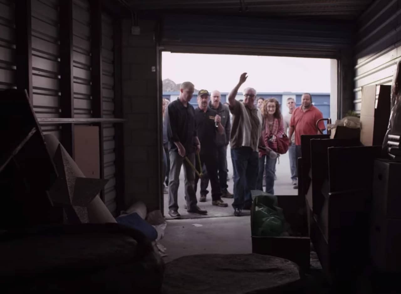 a group of people peer into a newly opened storage locker