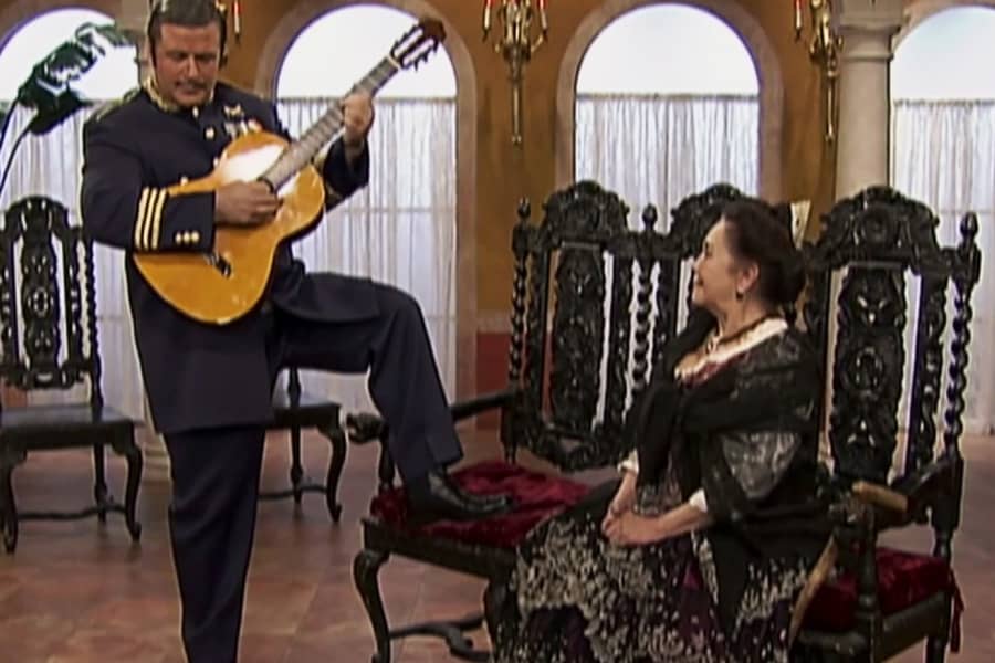El Generalissimo plays the guitar for an older woman