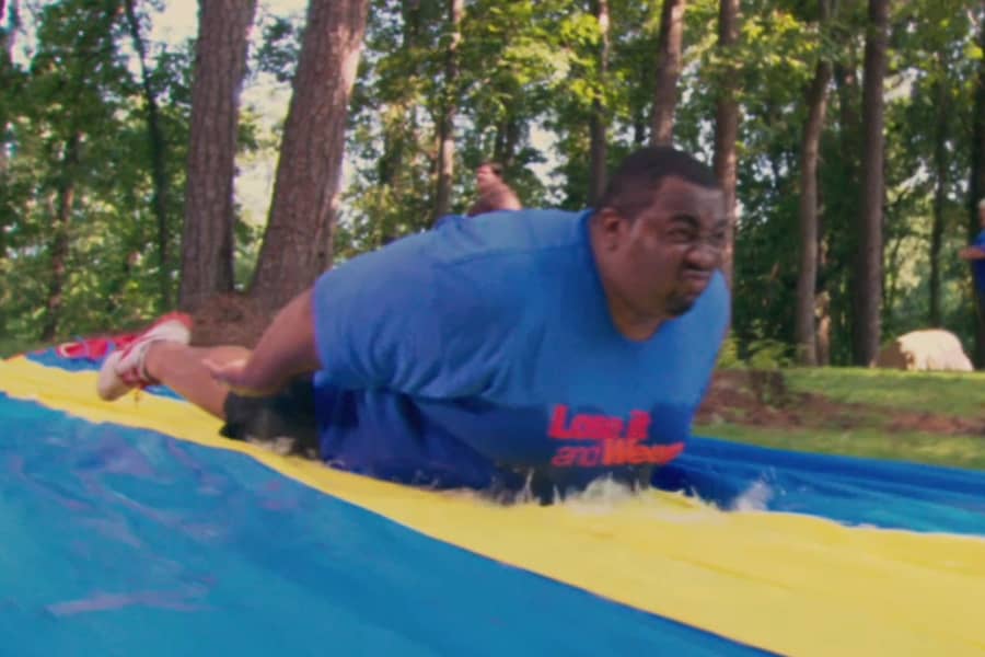 contestant sliding along a slip and slide