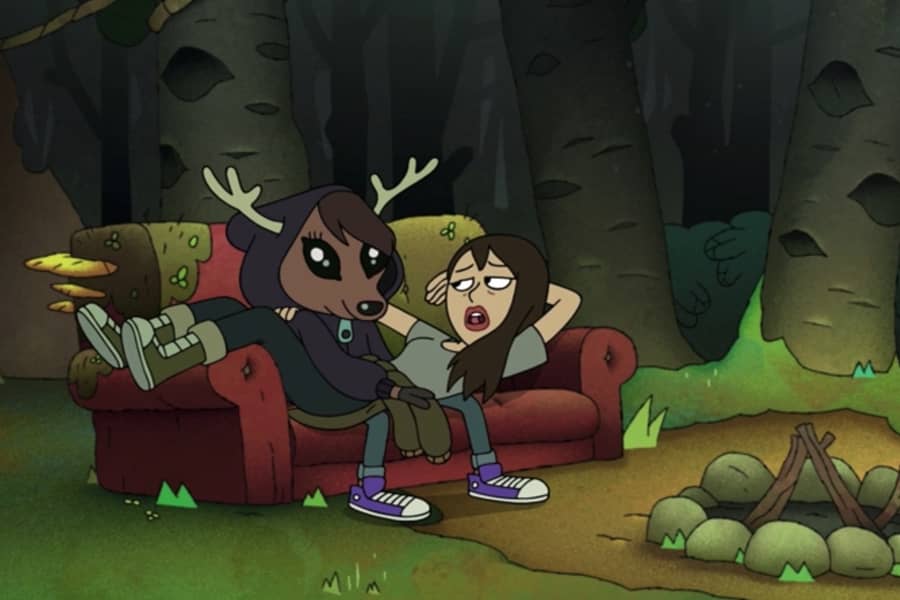 a deer boy (Alastair) in a hoodie sits on a couch in the woods with Constance