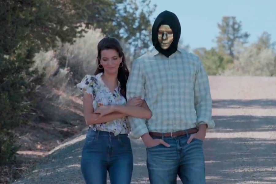 gold face mask walking arm and arm with a different woman