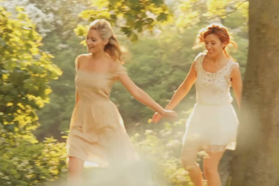 the women run through the woods in light flowing dresses, the vibe is ethereal