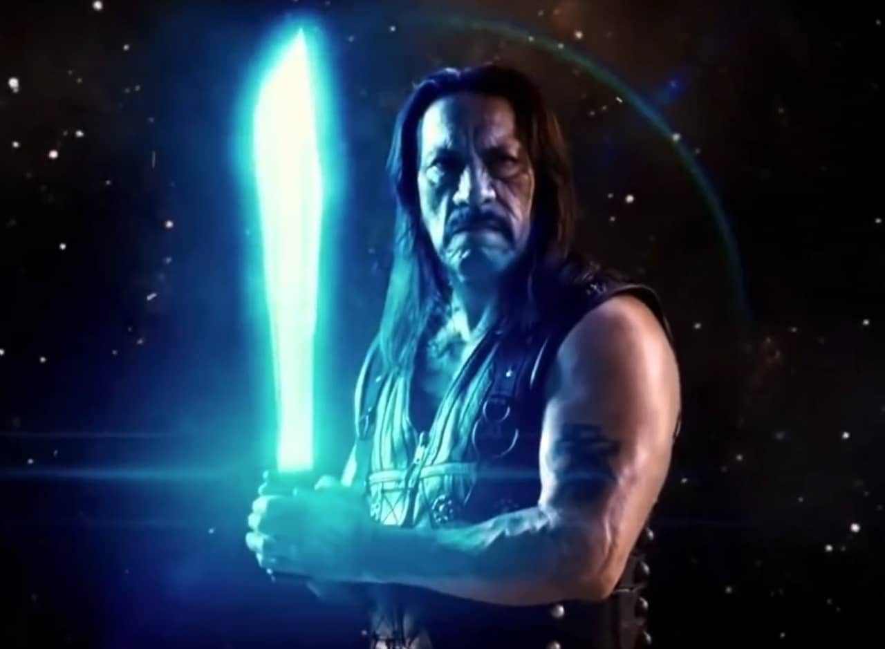Machete, with starry space behind him, holds his machete which is glowing like a light saber