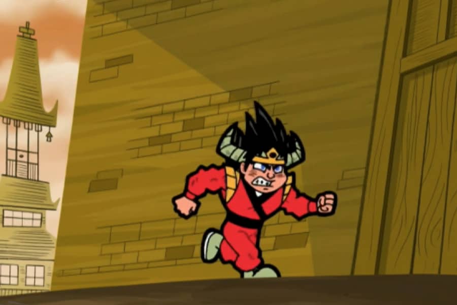 same boy running by a building