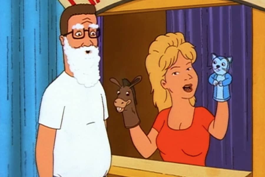 Luanne with her puppets next to Hank Hill in a white flowy beard