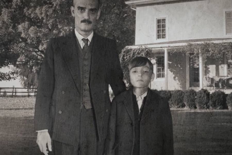 a black and white photo of a young boy and his father