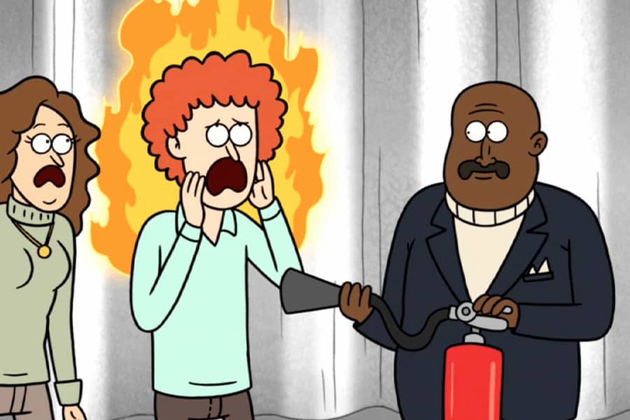 game show host holding a fire extinguisher next to a contestant on fire