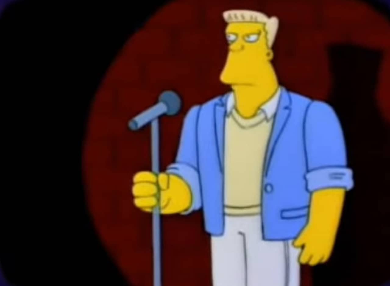 McBain on stage at a comedy club