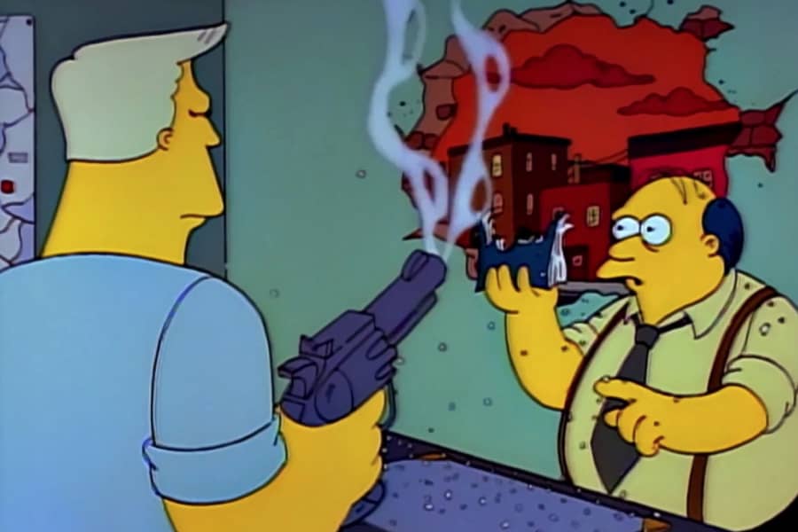 McBain shoots a hole in a manual the police chief is holding and the wall behind it