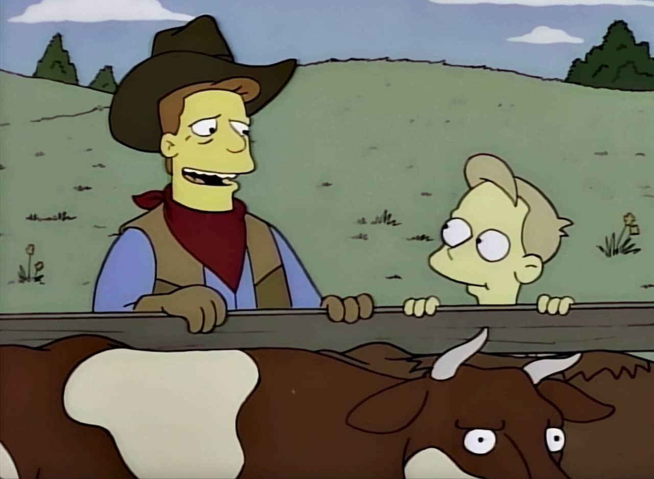 Troy McClure, dressed as a cowboy, with a young kid near a pen of cows
