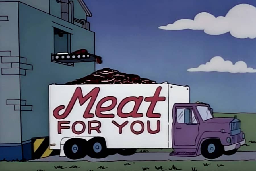 the factory is dumping meat into the back of a truck that says “Meat for You”