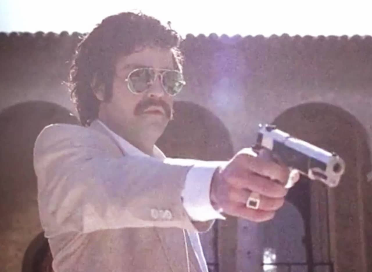Pablo Escobar points a gun