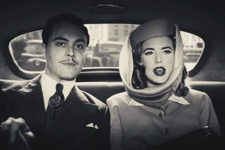 a man and woman dressed up in the back seat of a car