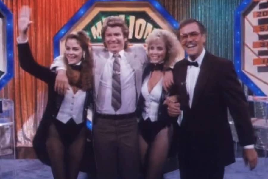 Benson with contestant McCormick who has his arms around two women assistants