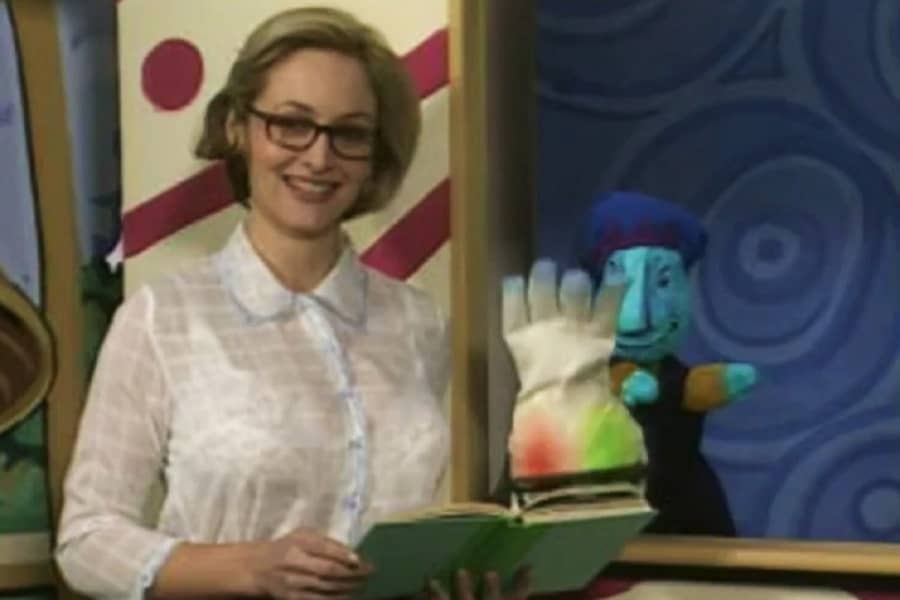 Miss Sally reads a book to her puppet pals