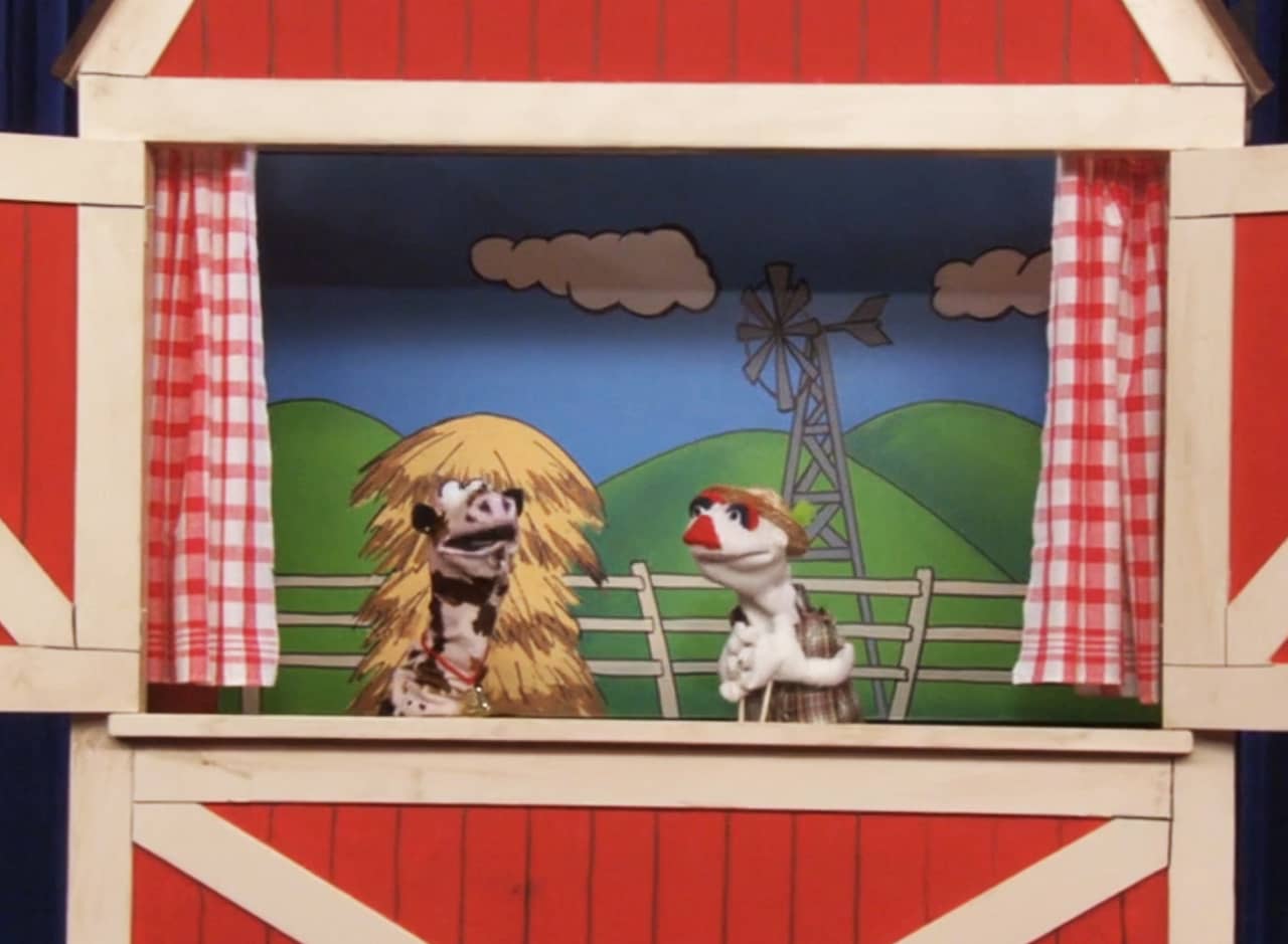 red barn puppet stage with Monty and Moo-Moo, farmer and cow sock puppets