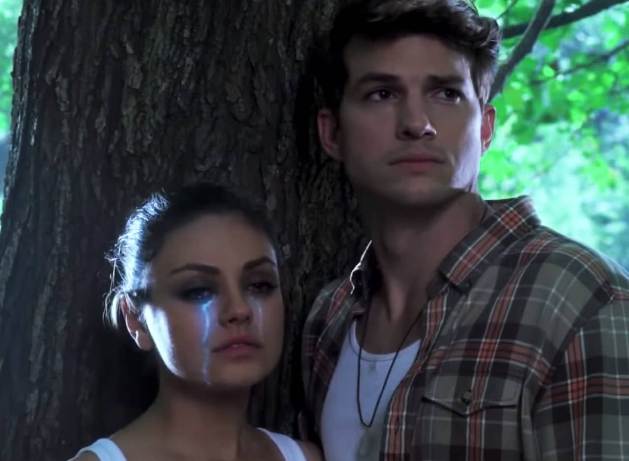 Mila Kunis as Andrea and Ashton Kutcher as Simon standing in the woods, Andrea is crying bright blue tears