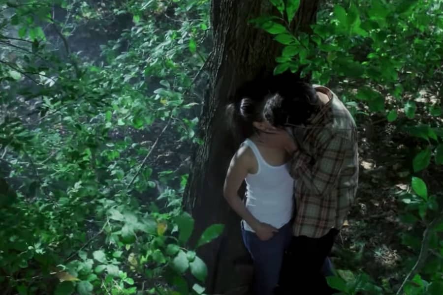 Andrea and Simon kissing in the woods