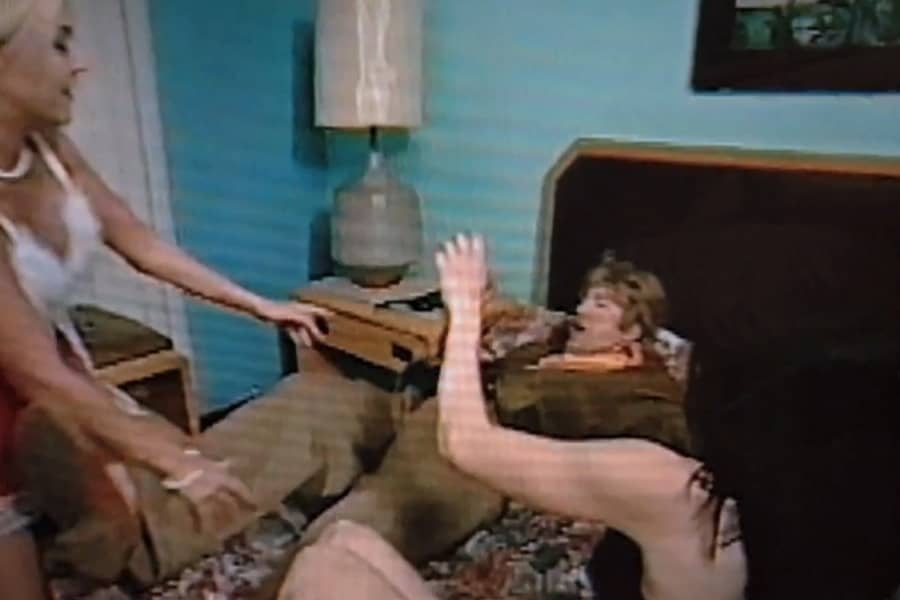 the women throw Gil on the bed