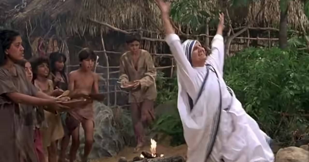 Mother Teresa, gleeful with arms raised, runs through a village with hungry children holding out empty bowls