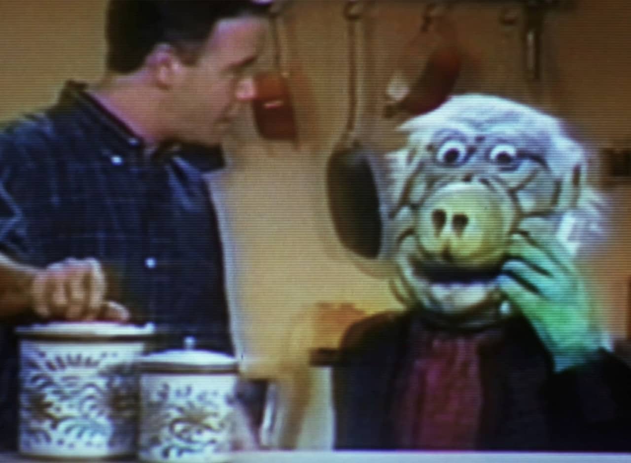Mr. Chompers holding a glass of milk in the Kitchen with Brad