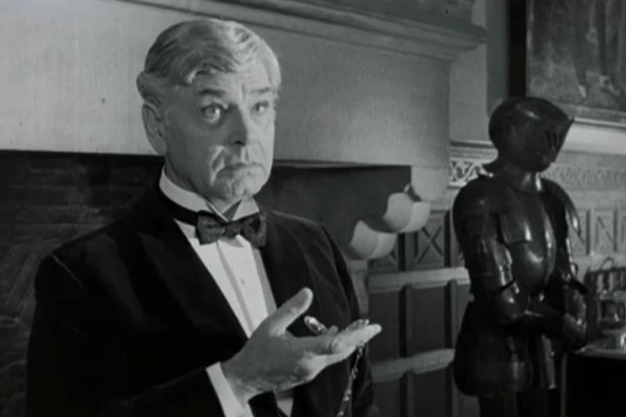man in tux looks at his pocket watch