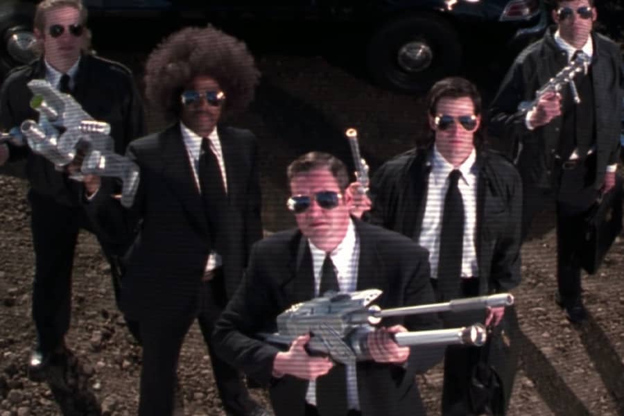 the men in black look up holding futuristic guns