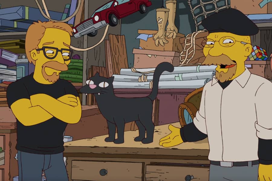 hosts in their workshop with a black cat