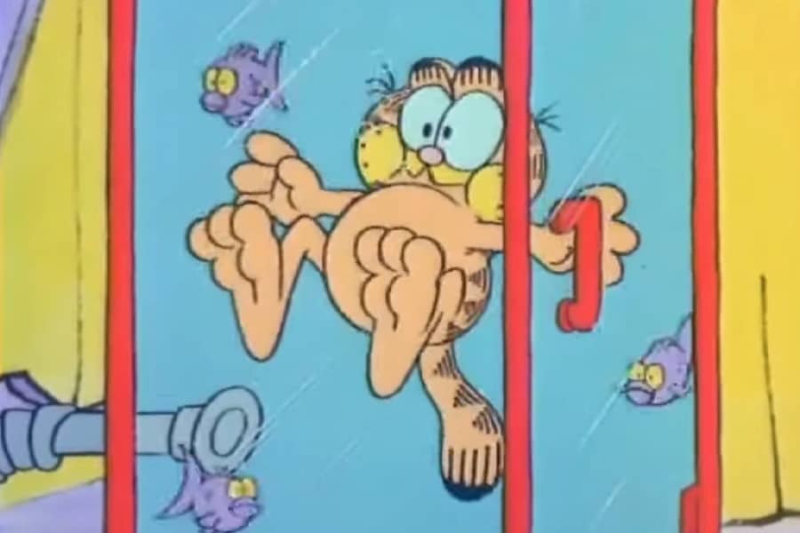 Garfield holding his breath and submerged in a glass case filled with water and fish