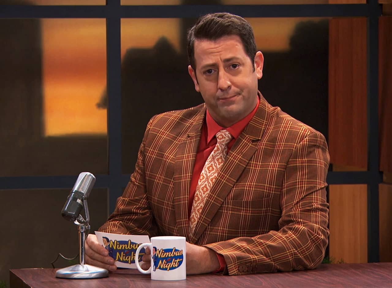 Johnny Nimbus at his desk wearing a plaid jacket