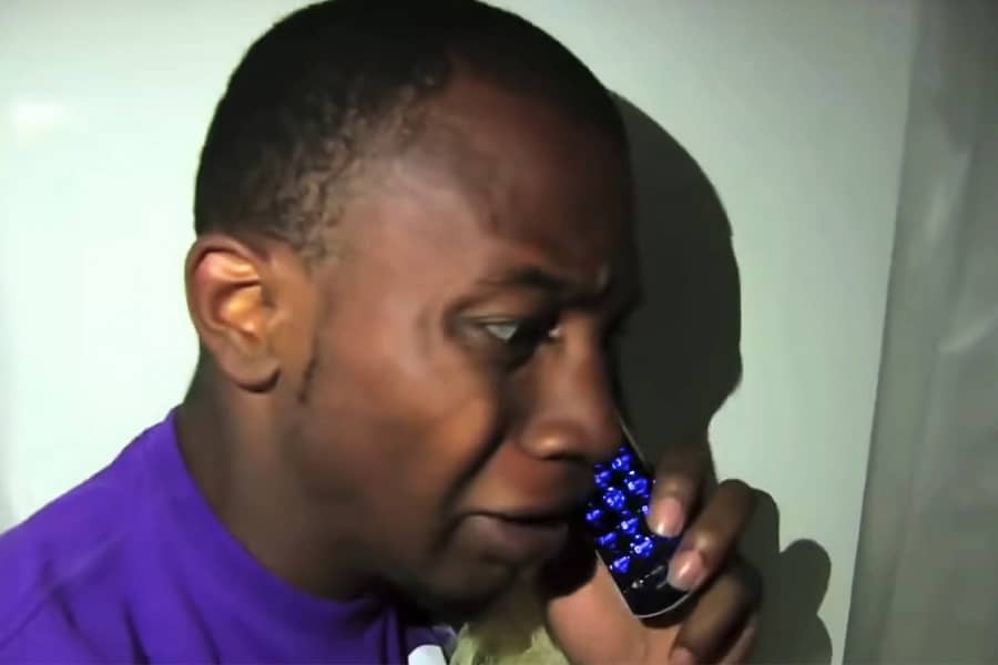 scared man hiding in the shower and on a cell phone