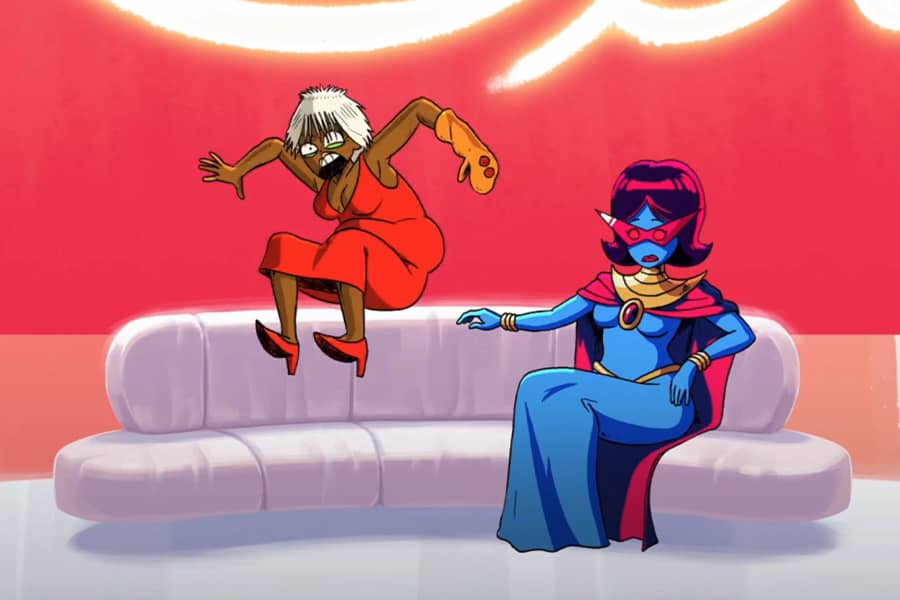 Obah sitting on the couch while her guest, Gaz Digzy, wears a sock puppet and jumps on the couch like an crazy person