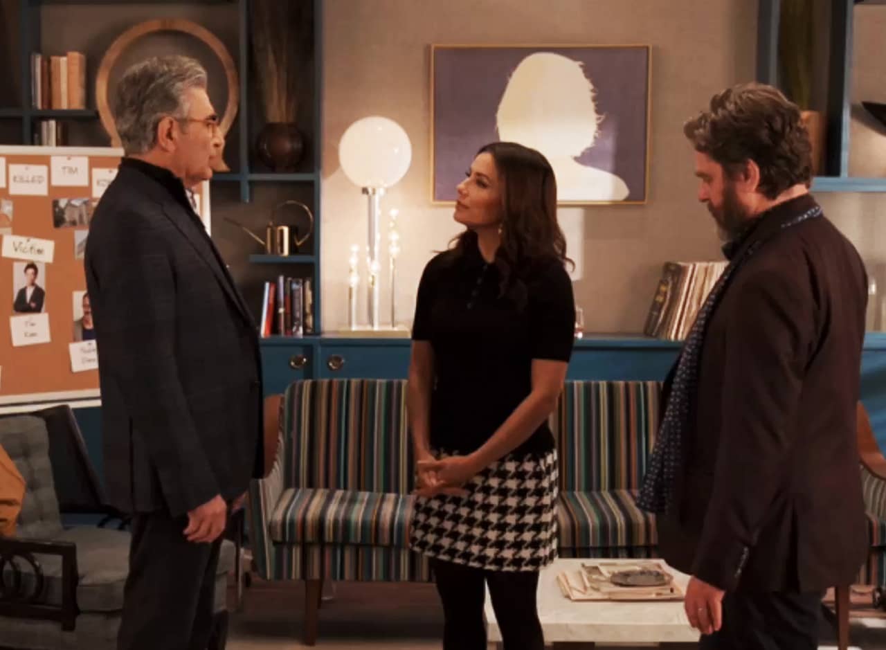 Eva, Zach, and Eugene in an apartment living room next to a pinboard of evidence