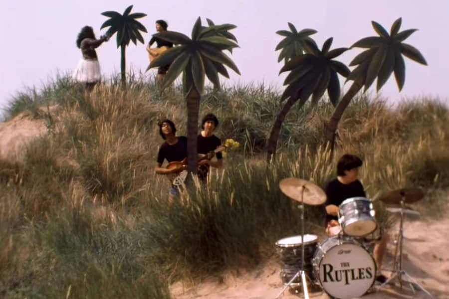 the Rutles performing in a desert oasis