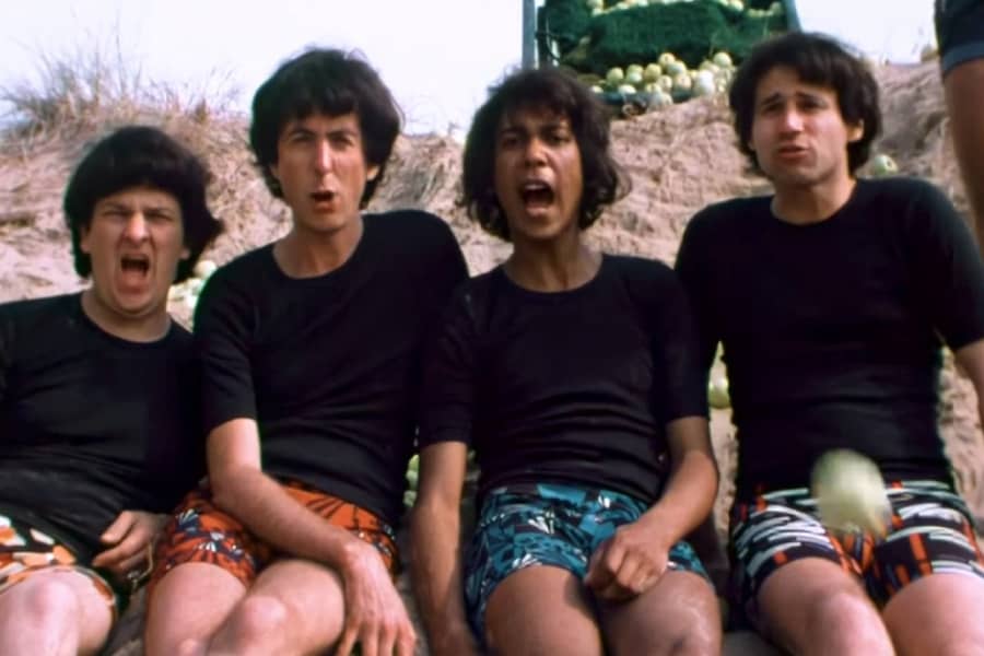 the Rutles sitting in the sand saying “Ouch!”