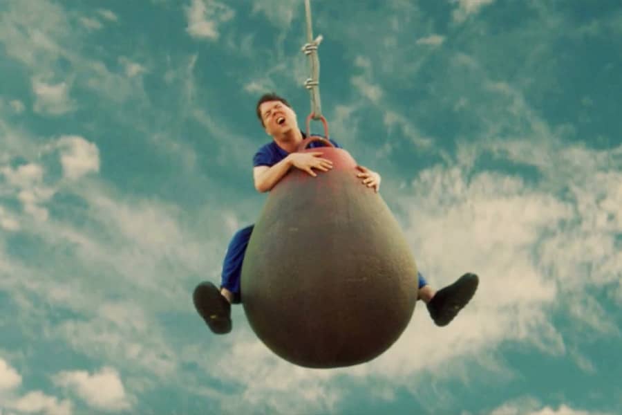 Chavez in pain, straddling a wrecking ball in the air