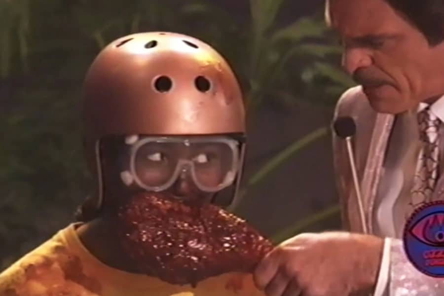 the host holds a giant turkey leg as a kid contestant eats it
