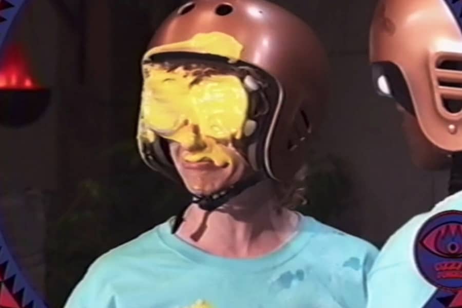 a kid has yellow goop all over his face and goggles