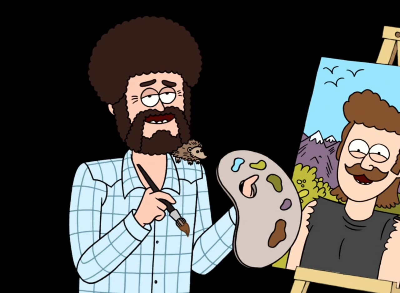 Benny Harris, bearded and curly haired artist, holding a palette next to a painting of a guy with a moustache