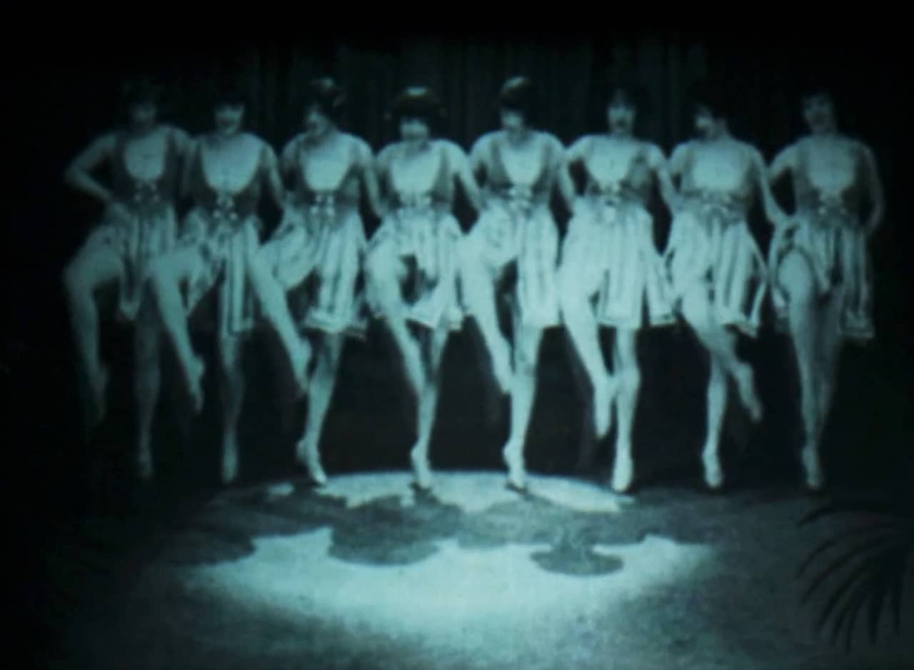 black and white shot of a line of women dancing