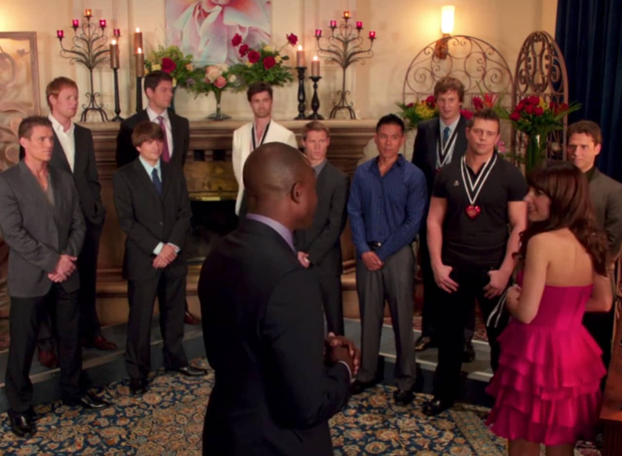 woman stands in front of rows of men in a heart ceremony