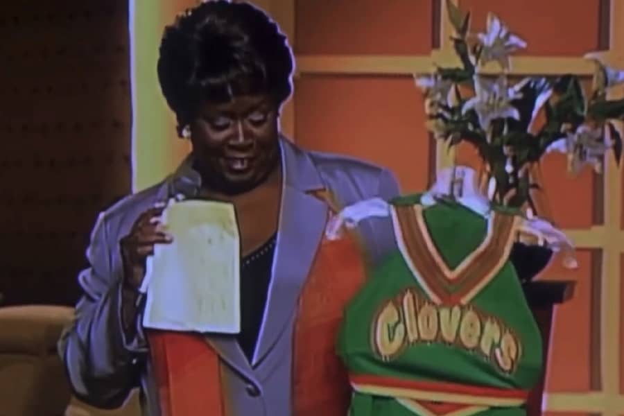 Pauletta holding up a Clovers cheer uniform