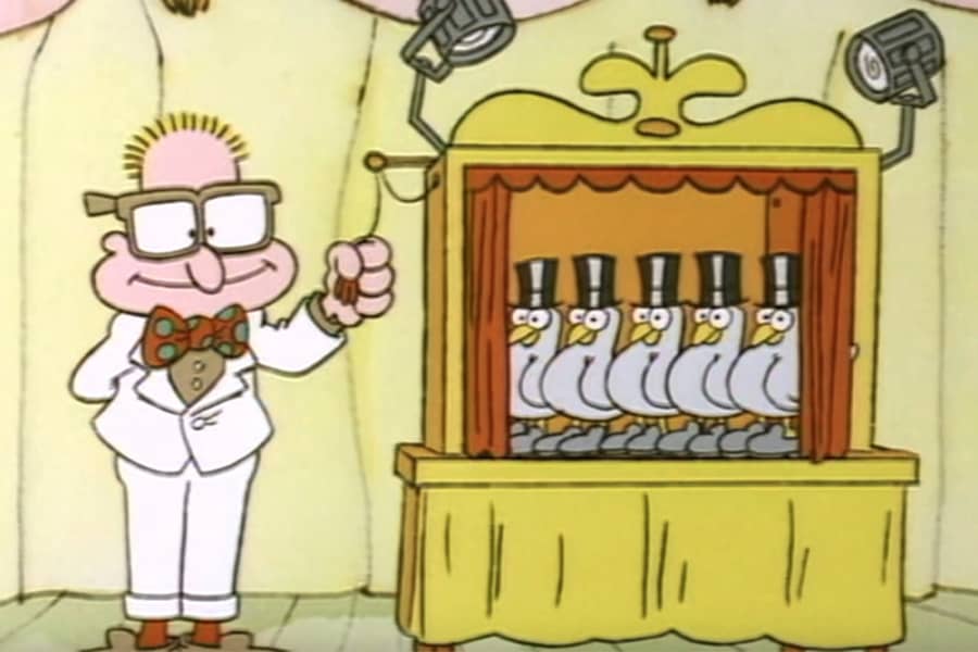 man with glasses reveals five pigeons wearing shoes and top hats