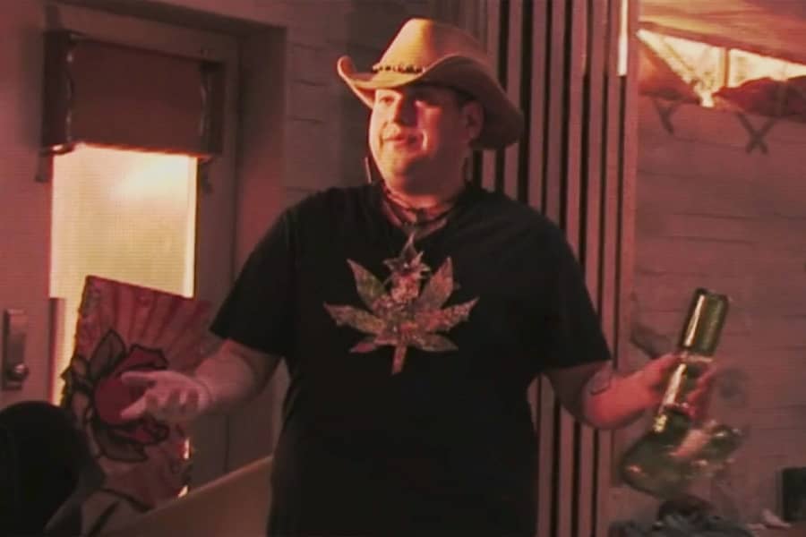Jonah Hill as Woody Harrelson, wearing a cowboy hat and holding a bong
